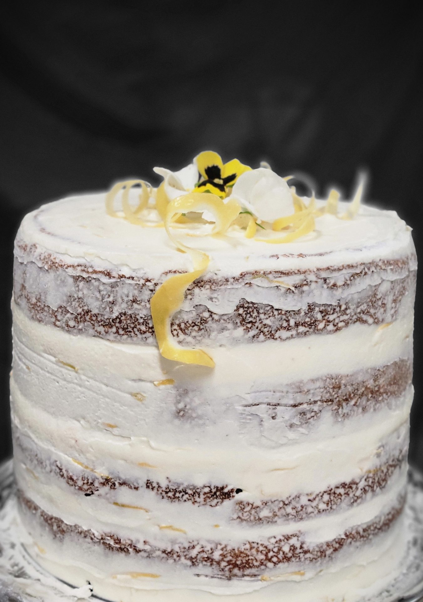 Naked lemon wedding cake with edible flowers